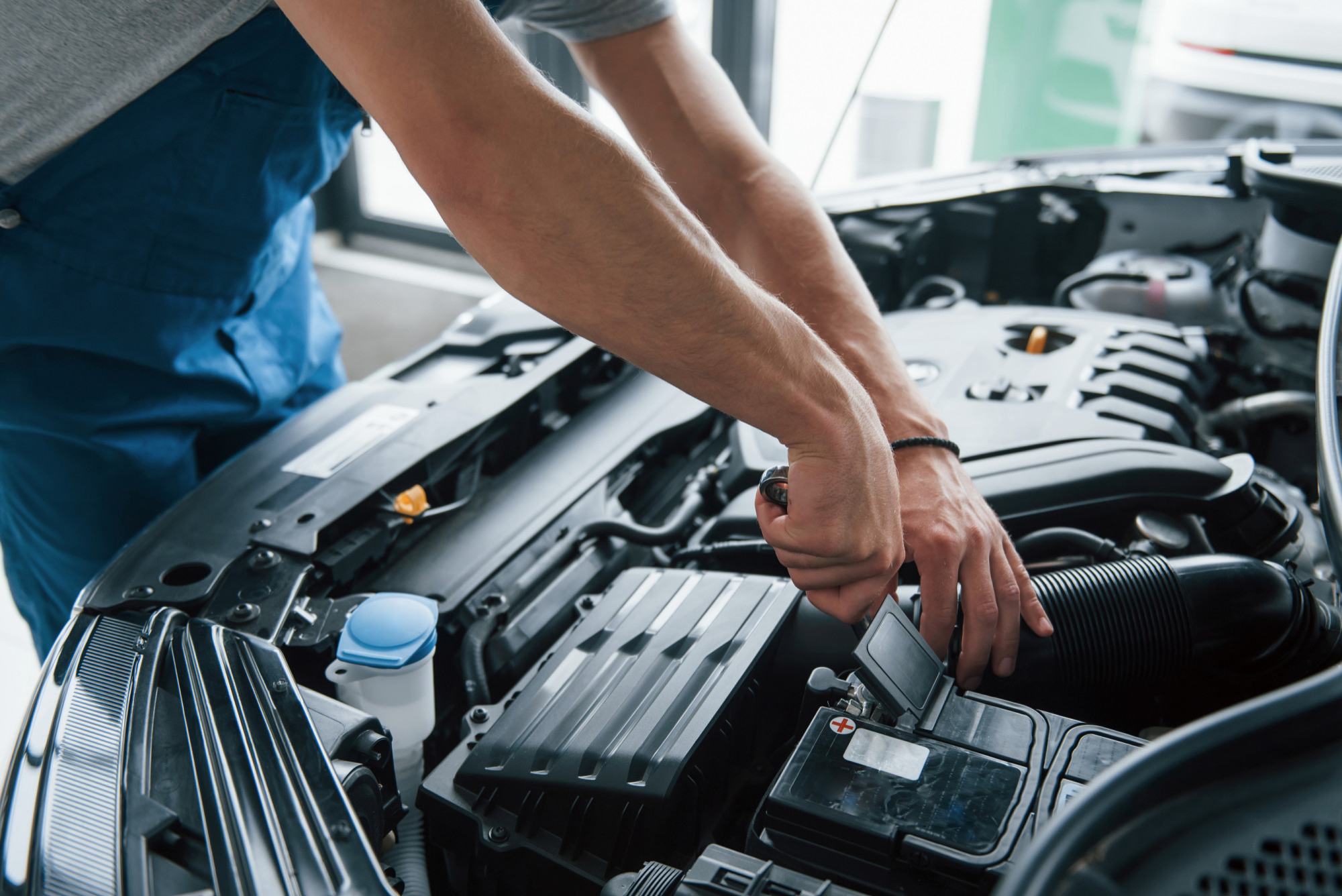 Mecânico realizando a troca de bateria automotiva